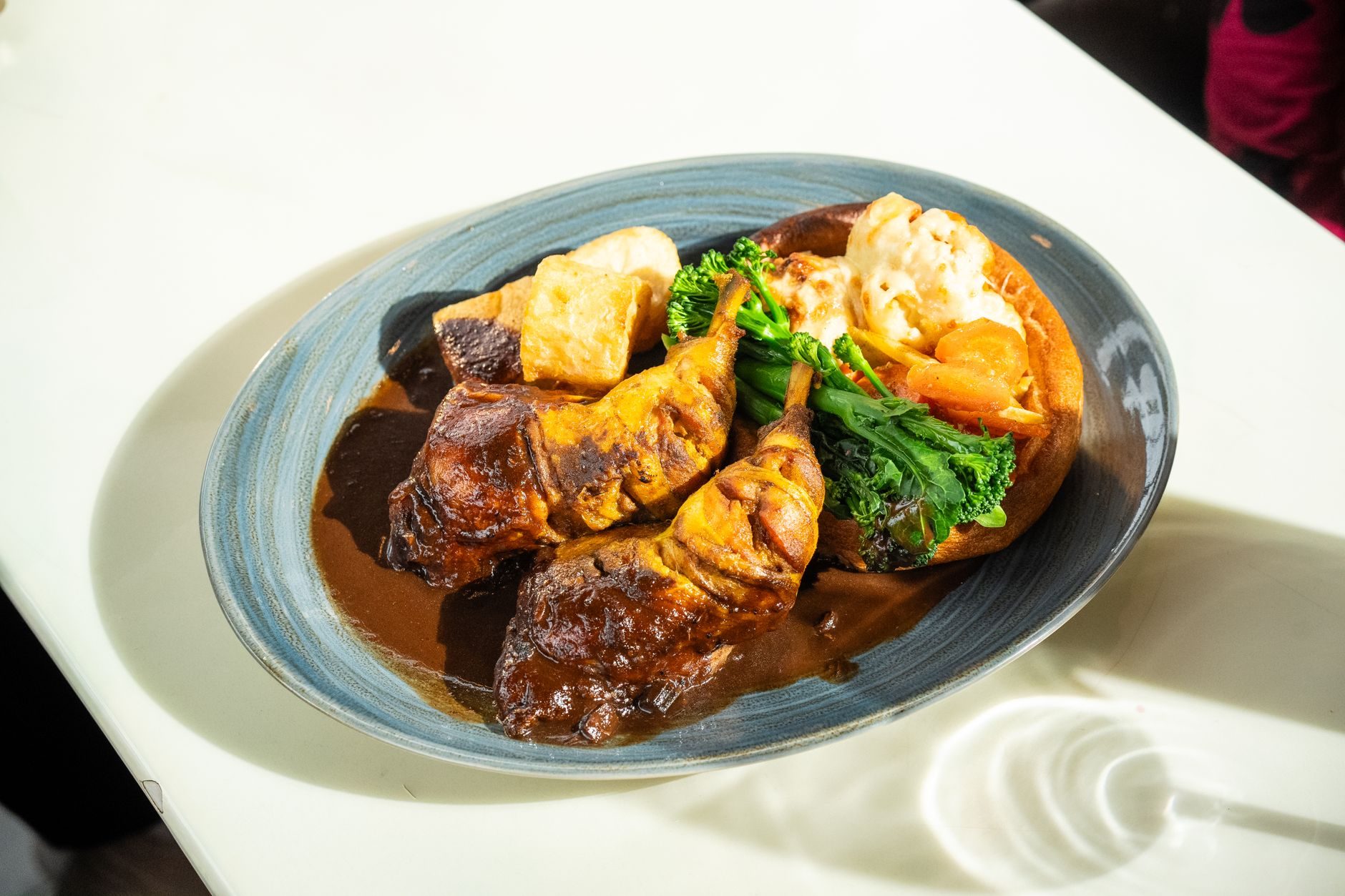 talerz pieczeni z wielkim yorkshire puddingiem polanym gravy
