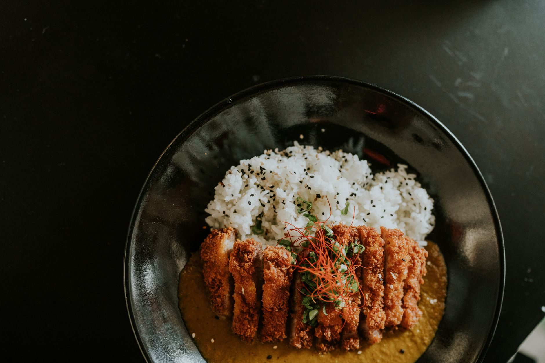 talerz ryżu z ciemnym japońskim curry i kotletem