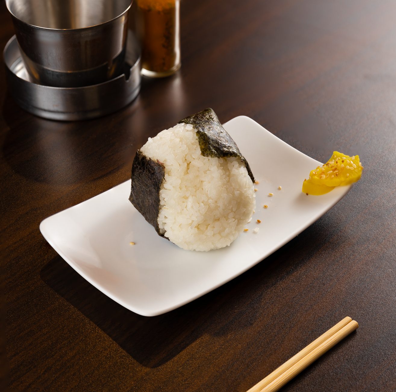 trójkątne onigiri w nori na tle półki konbini