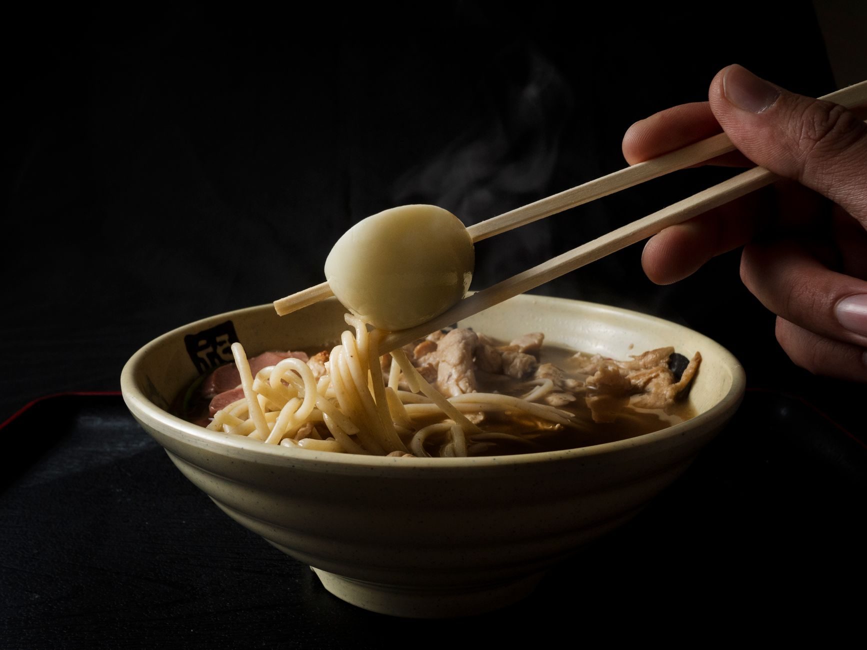 miska ramen z jajkiem przekrojonym na pół, chashu i nori